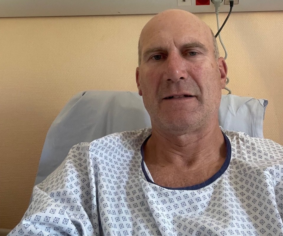 Man in hospital gown in a hospital bed.