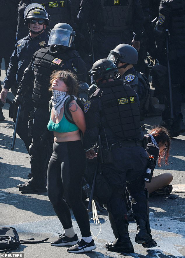 A demonstrator is detained by police officers during one of the protests on Sunday