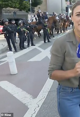 An LAPD officer was seen aiming his gun and firing a rubber bullet at Tomasi