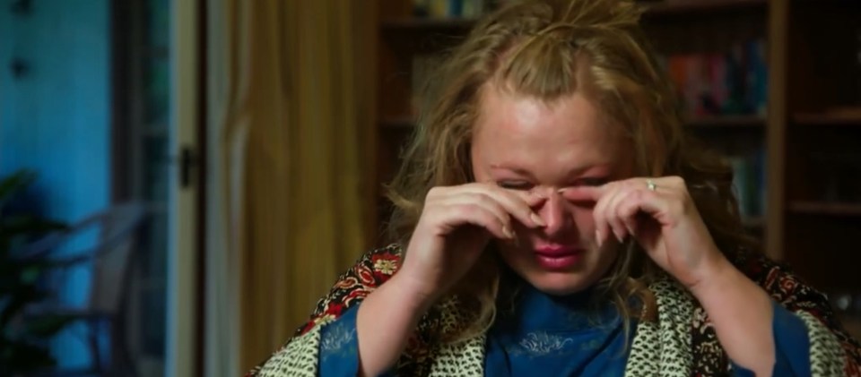 Screenshot of a woman crying.
