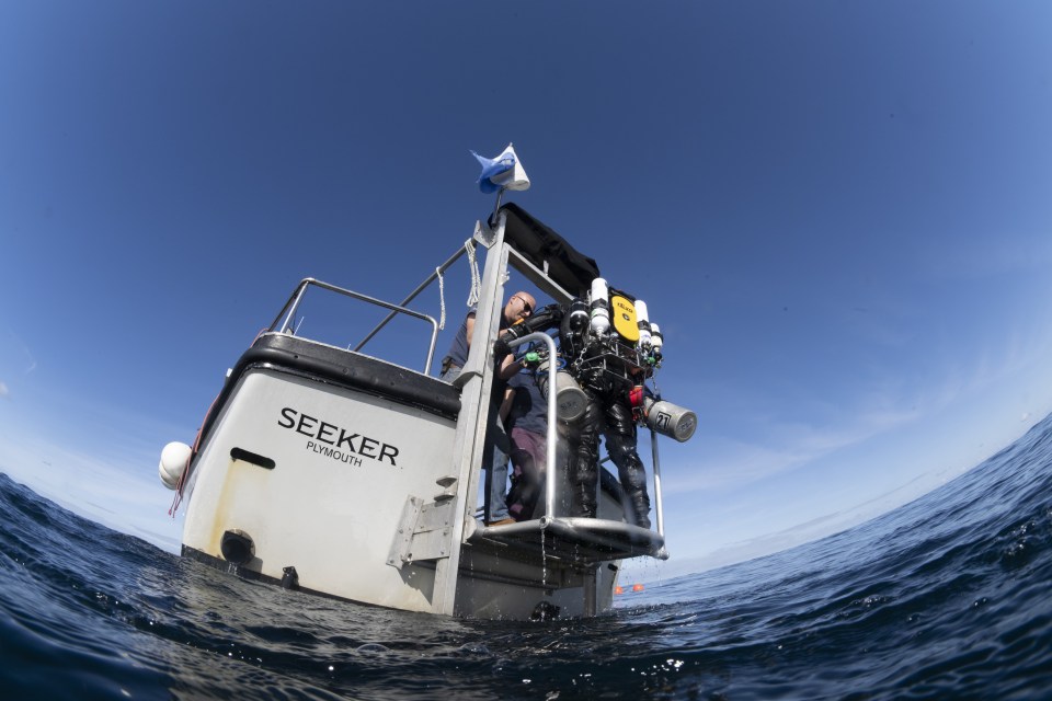 Divers preparing to dive from a boat.