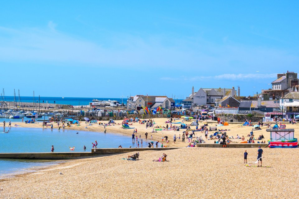Crowded beach in Lyme Regis, Dorset, UK on a sunny day.