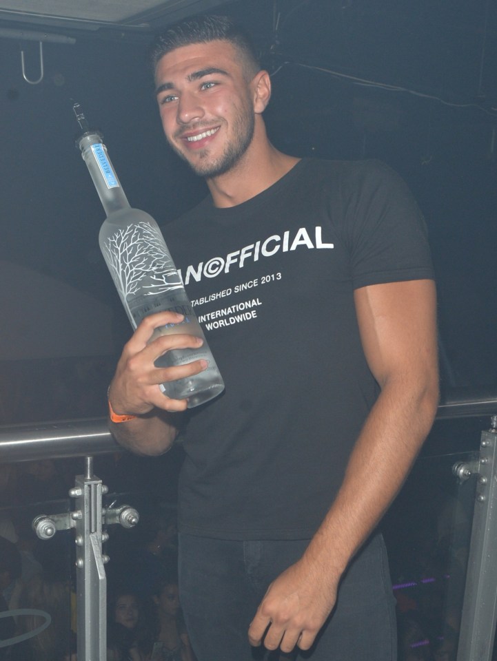 Tommy Fury holding a bottle of Belvedere vodka at a nightclub.