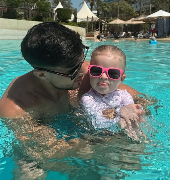 Tommy Fury and his daughter in a swimming pool.