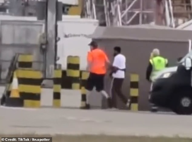 Eventually a van pulls up and two men are seen escorting the man away from danger