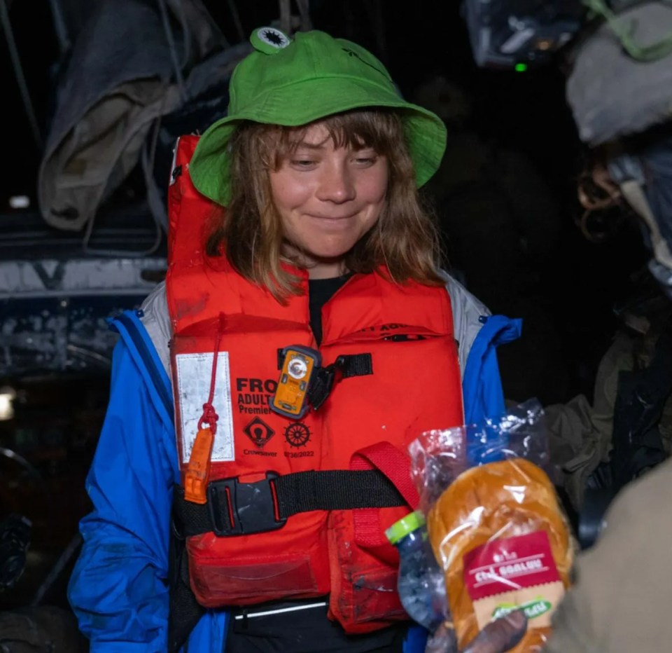 Woman in life vest receiving food.