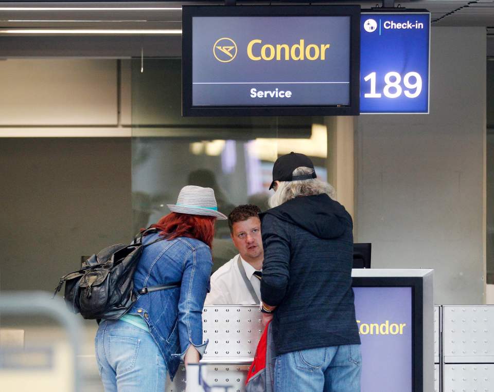 Passengers at a Condor airline check-in desk.