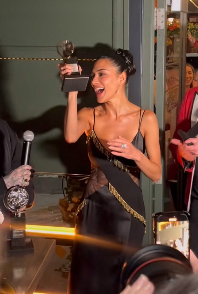 Nicole Scherzinger holding an award at an after-party.