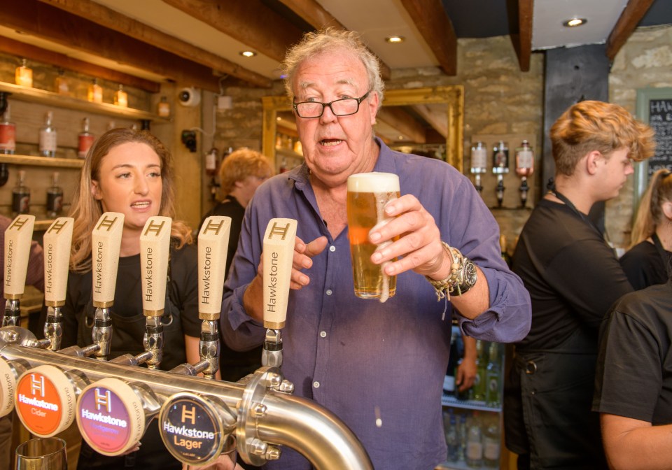 Jeremy Clarkson holding a pint of beer at a pub.