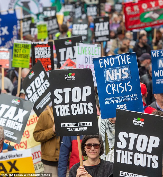 Protesters march through Piccadilly Circus in central London ahead of Rachel Reeves's spending review