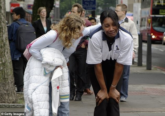 A distraught commuter is consoled after the series of explosions