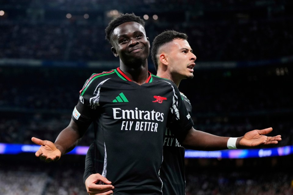 Arsenal's Bukayo Saka celebrates with Gabriel Martinelli, right, after scoring the opening goal during the Champions League quarterfinals second leg soccer match between Real Madrid and Arsenal at the Santiago Bernabeu stadium in Madrid, Wednesday, April 16, 2025. (AP Photo/Manu Fernandez)