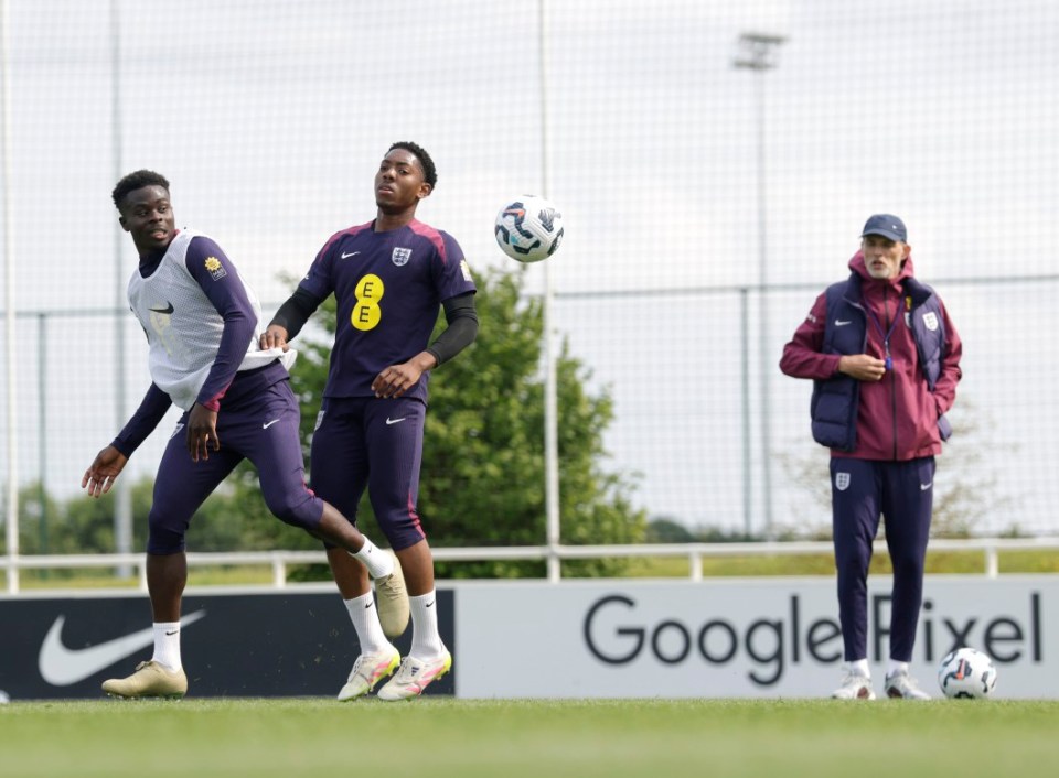 BURTON-UPON-TRENT, ENGLAND - JUNE 08: Myles Lewis-Skelly and Bukayo Saka of England battle for possession as Thomas Tuchel, Head Coach of England, looks on during a training session at St Georges Park on June 08, 2025 in Burton-upon-Trent, England. (Photo by Eddie Keogh - The FA/The FA via Getty Images)