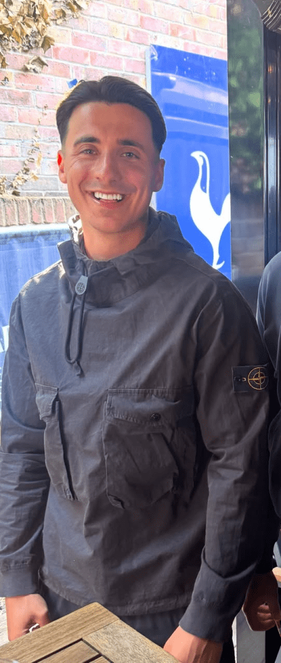 Man smiling, wearing a dark gray jacket.
