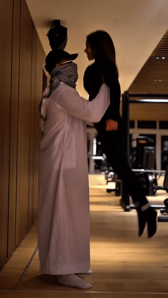 Man lifting woman in gym.