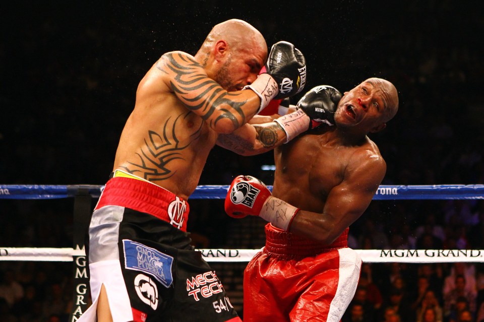 Miguel Cotto landing a left punch on Floyd Mayweather Jr. during a boxing match.