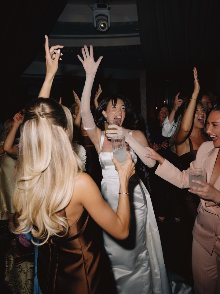 Bride dancing with friends at a wedding reception.