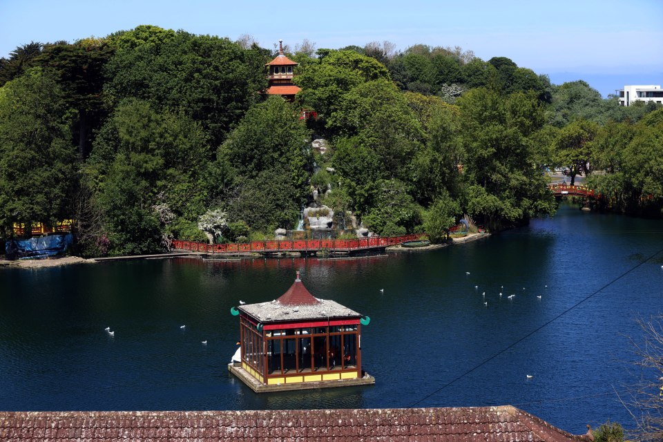 High-angle view of a lake with a gazebo and pagoda in a park.