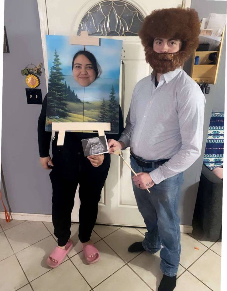 Couple in Bob Ross and happy little tree costume announcing pregnancy.