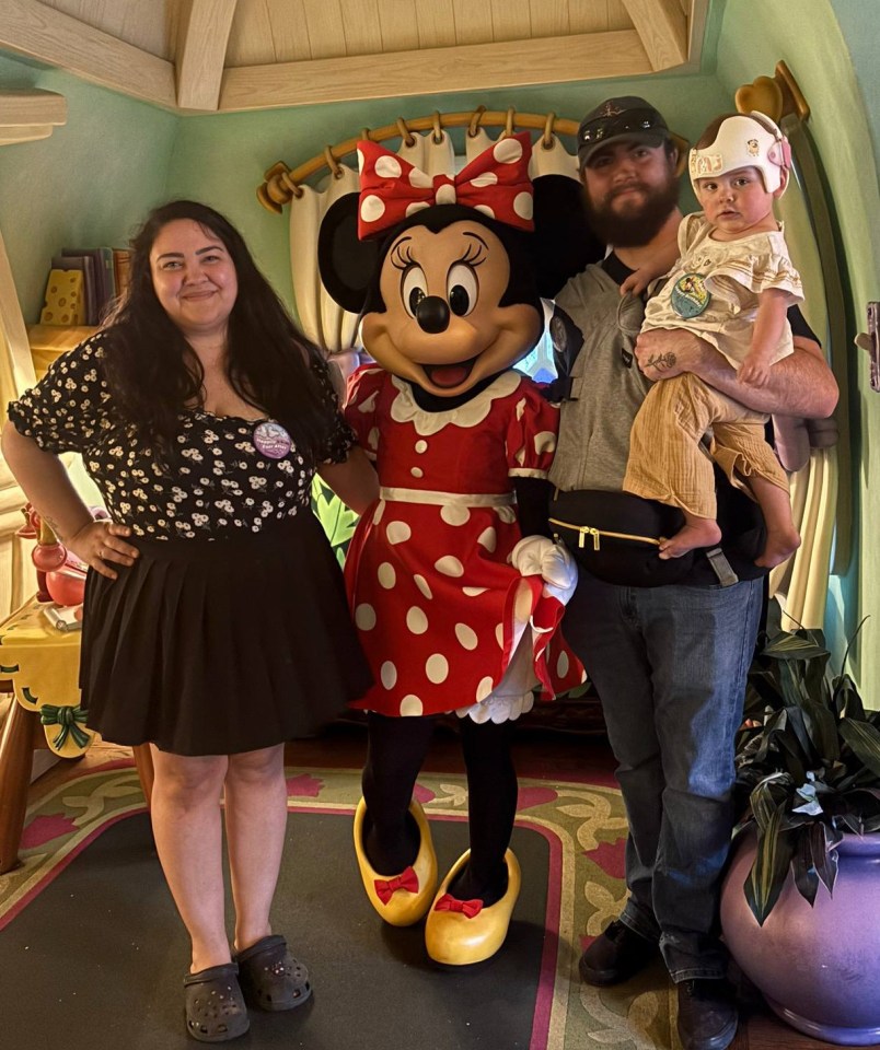 Family posing with Minnie Mouse.