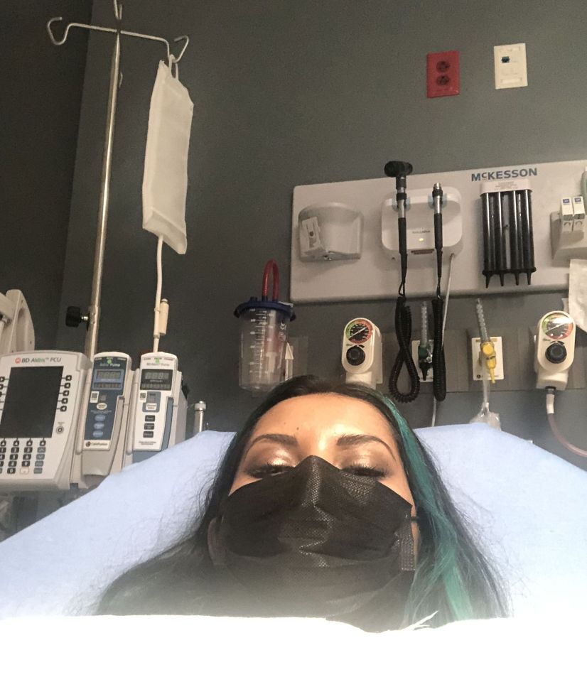 Woman in hospital bed wearing a face mask.