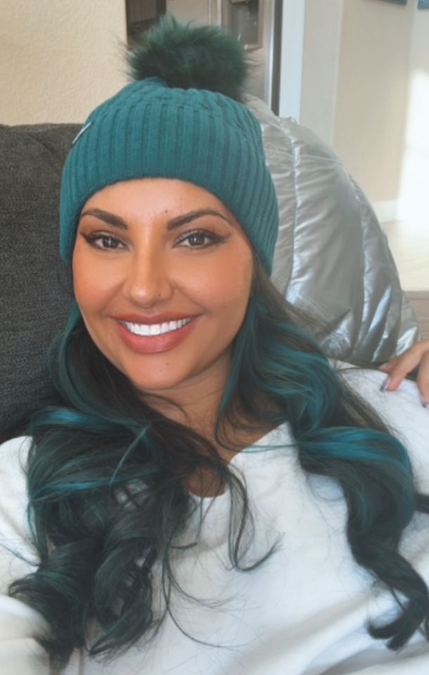 Woman with teal hair wearing a teal knit beanie.