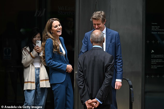 The mother-of-three shares a laugh with officials at the V&A East Storehouse
