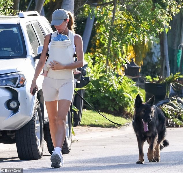 The 44-year-old Versace model also had her dog's black leash tied around her torso in what is called a 'hands-free leash.' Having both her dog and her baby attached to her body could potentially be dangerous if the canine runs off to chase a squirrel and drags their owner down to the ground. The baby could be hurt
