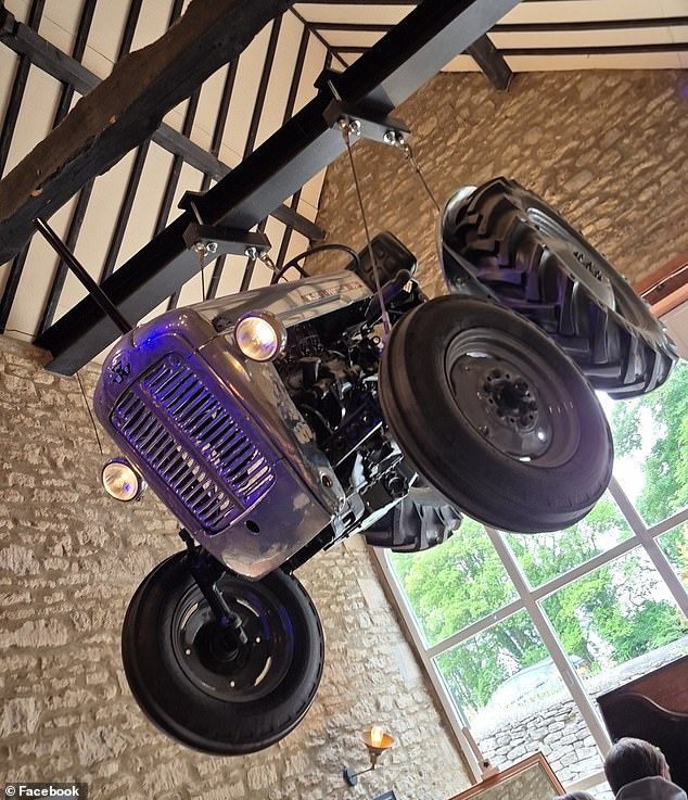 A tractor pictured hanging from the ceiling of the pub, which has been dividing internet users lately with its prices