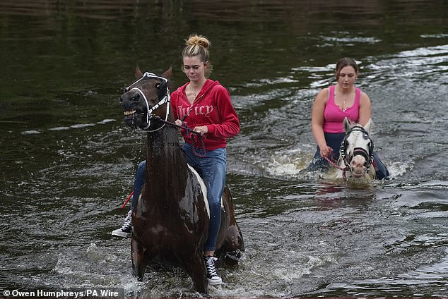 People riding horses in water during the Appleby Horse Fair in Cumbria on Sunday