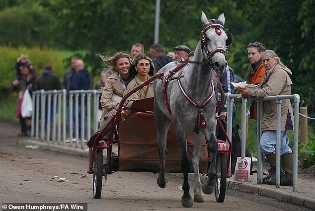 People in a horse drawn carriage during the annual Appleby Horse Fair gathering on Sunday