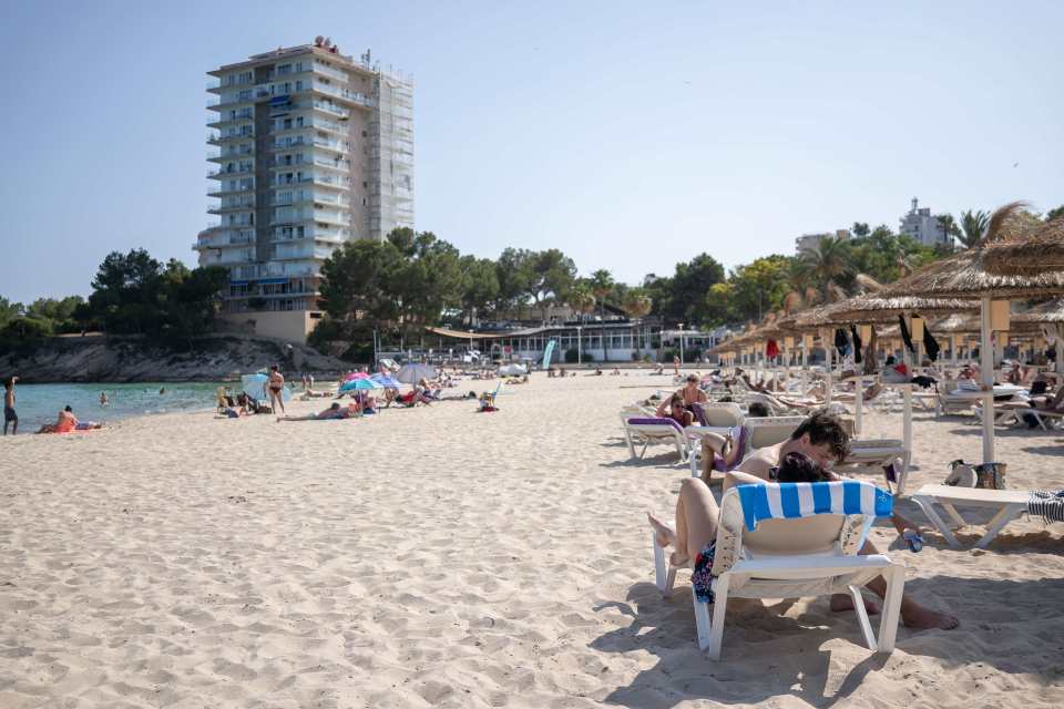 Magaluf beach with sparsely occupied sunbeds.