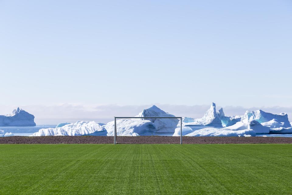 Soccer field goal with icebergs in the background.