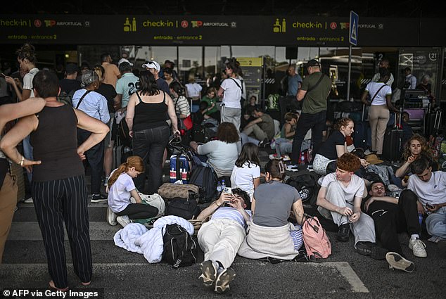 People with their luggage wait outside Humberto Delgado airport following a general electricity shutdown in Lisbon on April 28, 2025