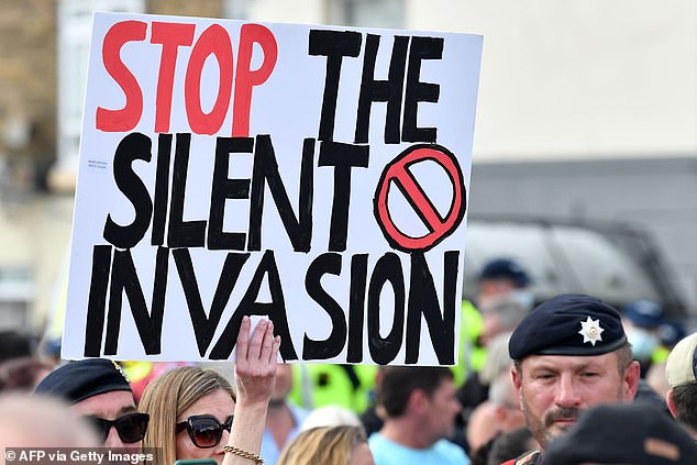 An anti-immigration protester holds up a placard during a demo in Dover in 2020