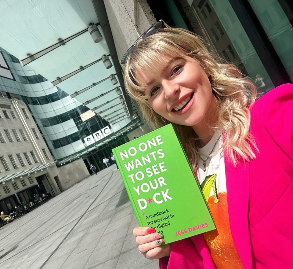 Woman holding her book "No One Wants to See Your D*ck" outside the BBC.