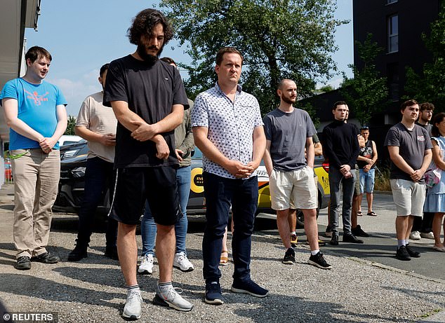 eople gather to observe a minute of silence in honour of the victims of a deadly shooting at a secondary school