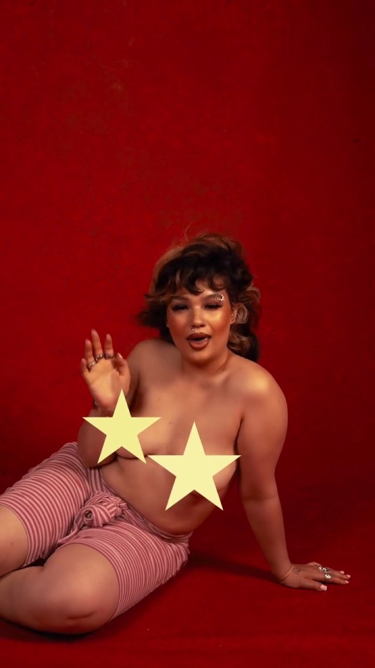 Woman in pink striped shorts sitting on a red background.