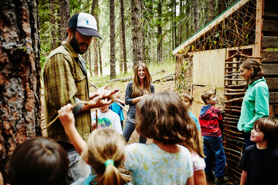 Camp counselors instructing children at summer camp.