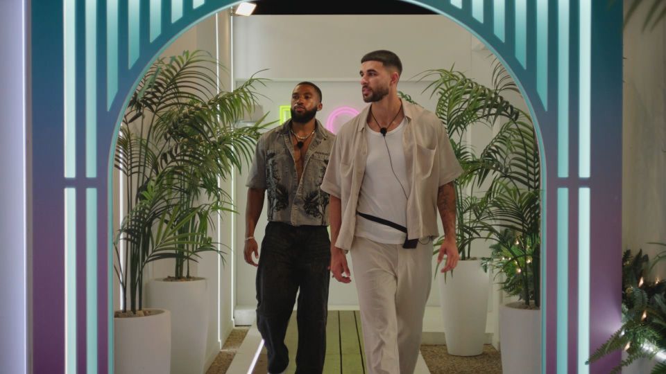 Two men walking through an archway.