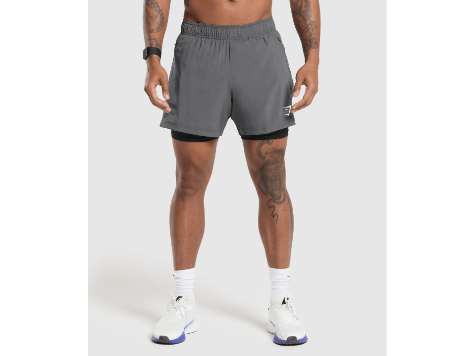 a man with a tattoo on his leg is wearing grey shorts