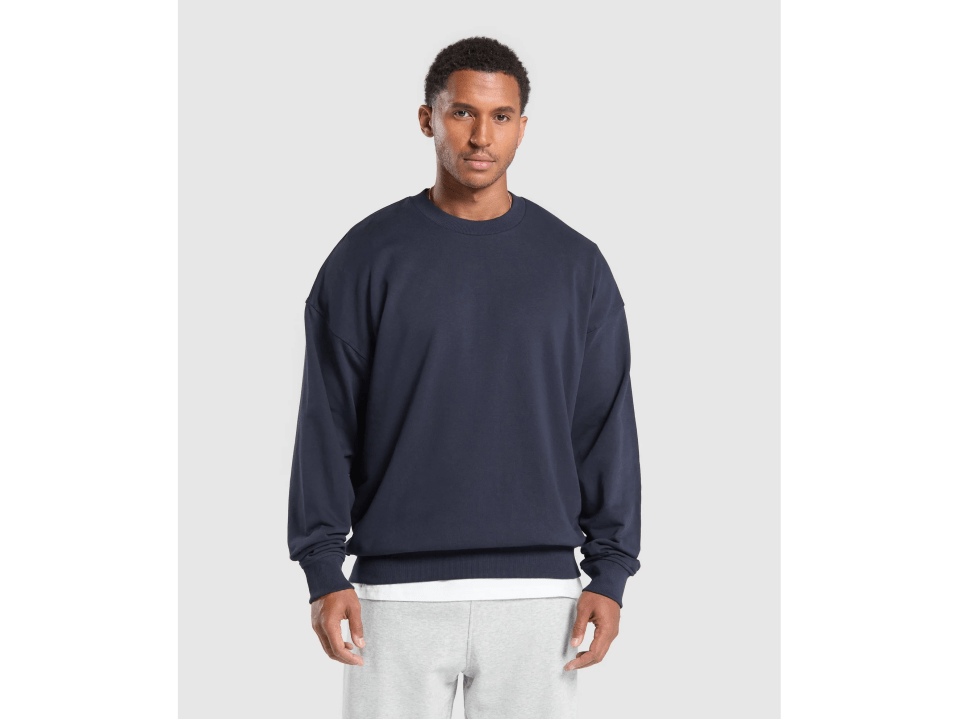 a man wearing a blue sweatshirt and grey sweatpants