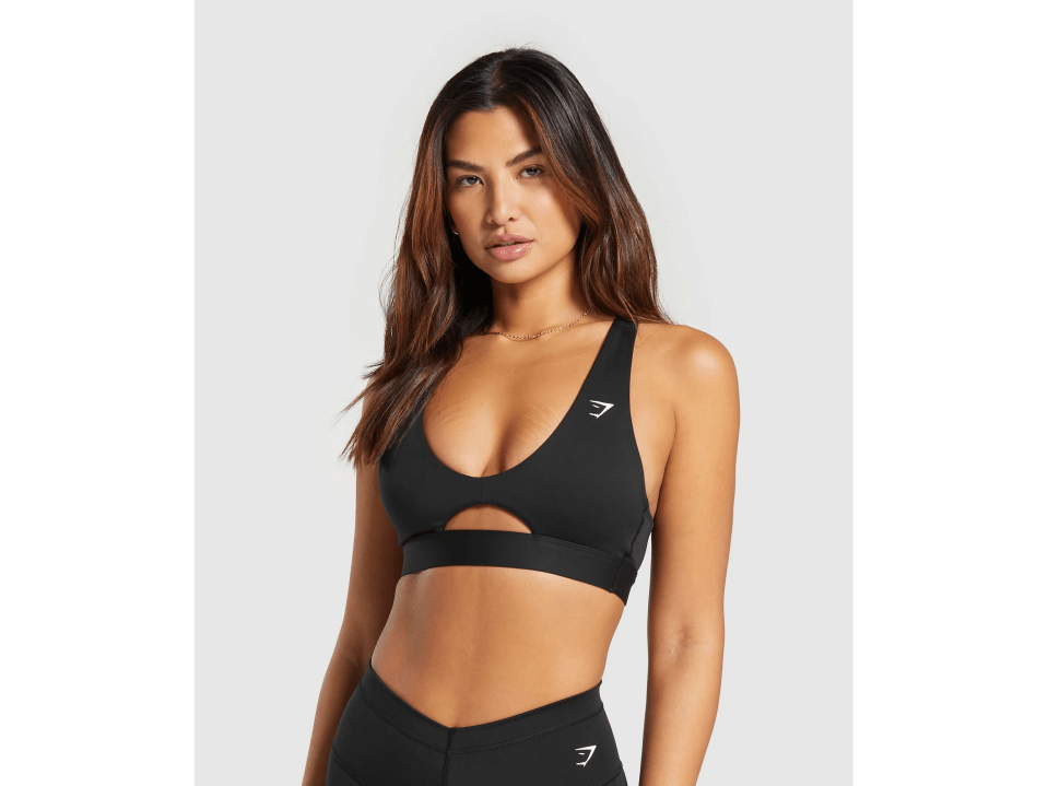 a woman wearing a black sports bra with the letter g on it