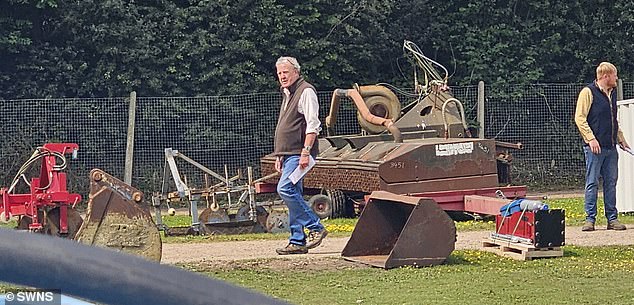The former Top Gear presenter seen walking among pieces of farm machinery at the tractor sale in Sutton, near Ely in Cambridgeshire. His trusted farm manager Kaleb Cooper (right) was also spotted at the event
