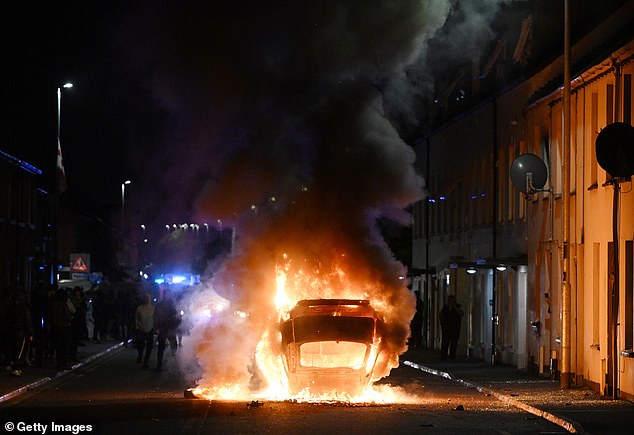 A vehicle burns on the street of Ballymena as violence continued for the second night in a row