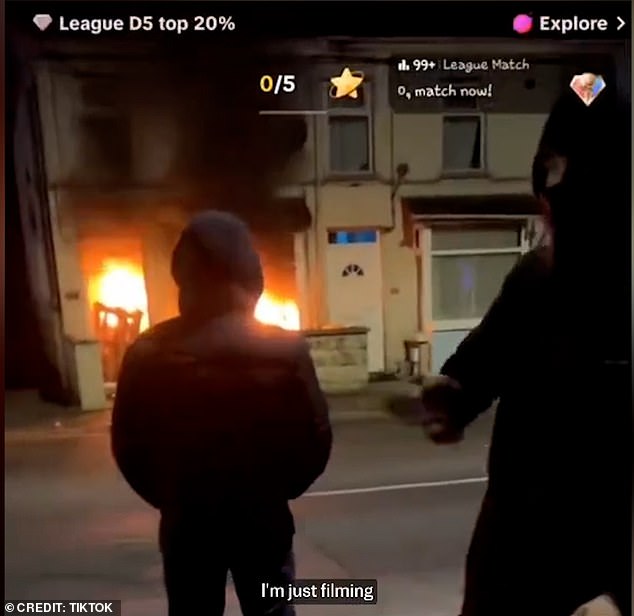 The person behind the camera tells viewers to 'rack them gifts up, boys' as he begs for likes and follows in front of the burning building