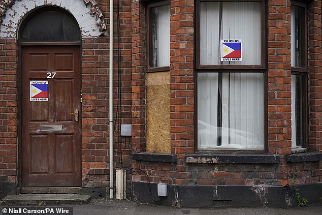 A boarded-up window on a property damaged in Ballymena today after a second night of violence