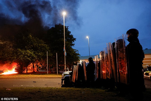 Officers line up as the riots continue to erupt into complete chaos for the second night in a row