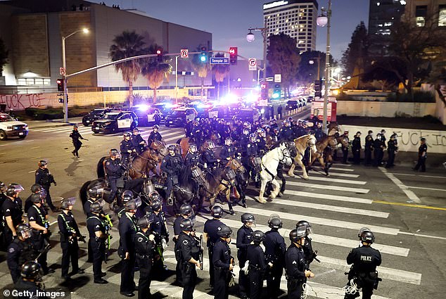 Despite the curfew order having been called, some protestors - waving flags and yelling - defiantly stared down police who watched on and stood their ground rather than make arrests
