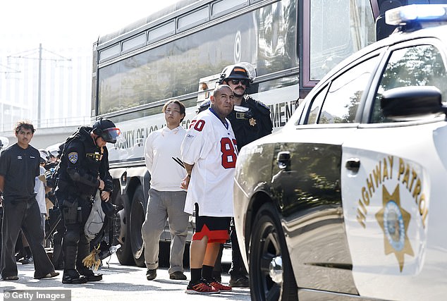 California Highway Patrol (CHP) officers detain protesters near the 101 freeway ahead of Los Angeles being put on lockdown